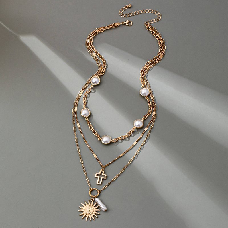 MULTI PEARL LAYER PEARL SUN CROSS CHARM NECKLACE