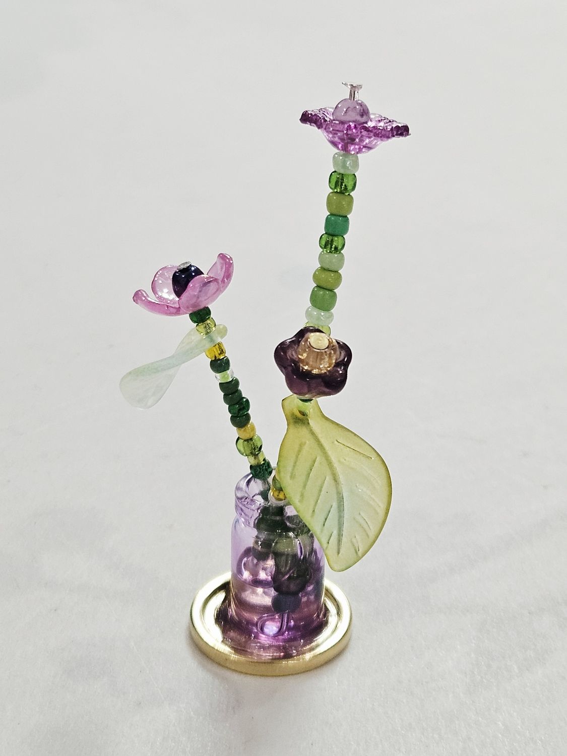 Purple beaded flowers in mini purple vase