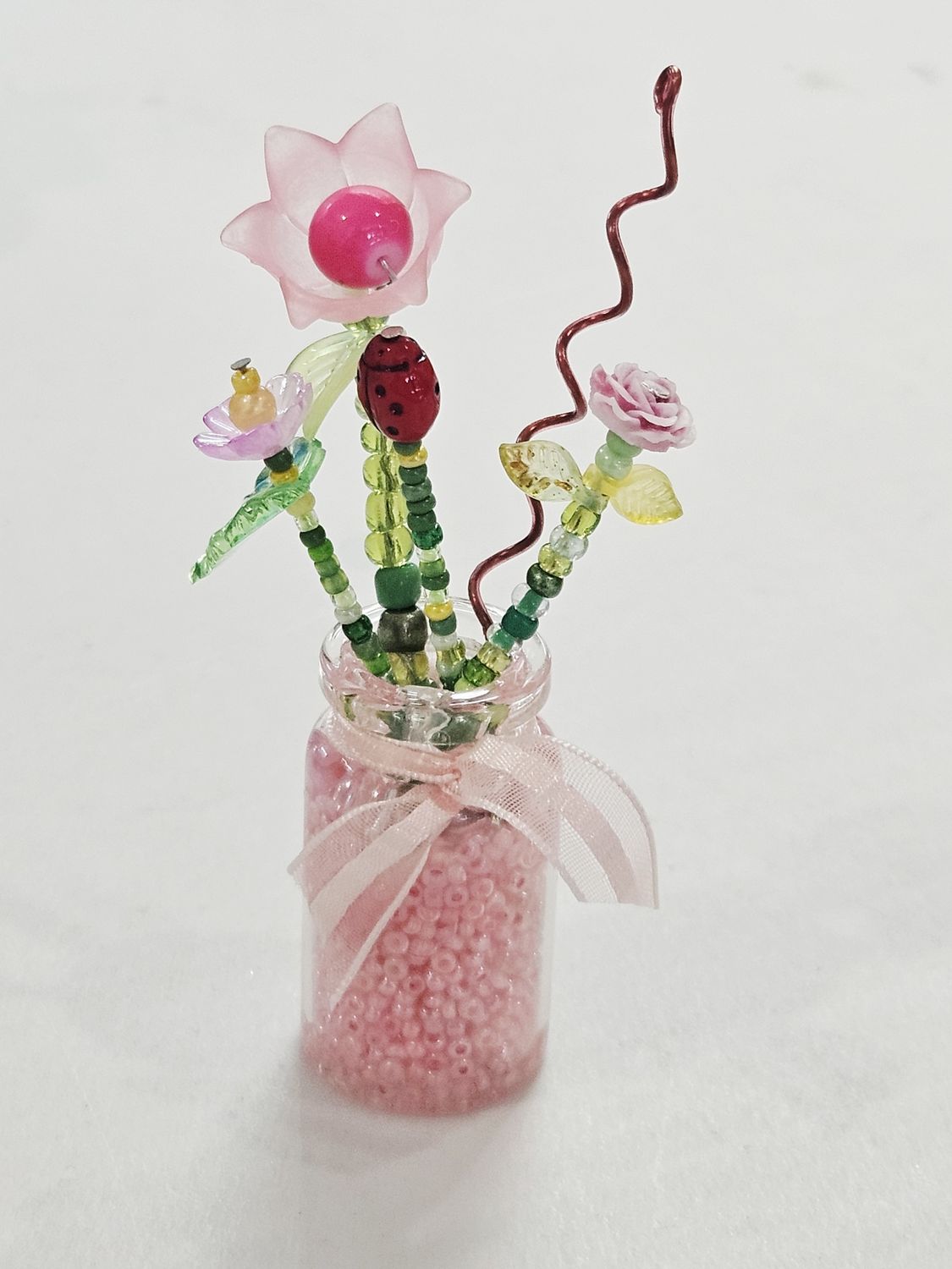 Pink Beaded Flowers with Ladybug in Clear Vase