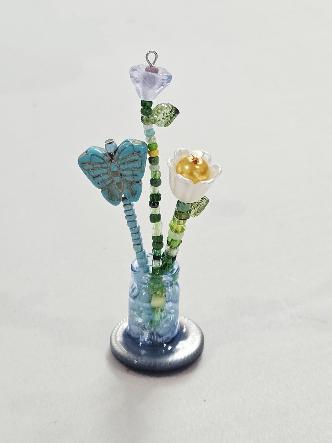 Blue and white beaded flowers in mini blue vase
