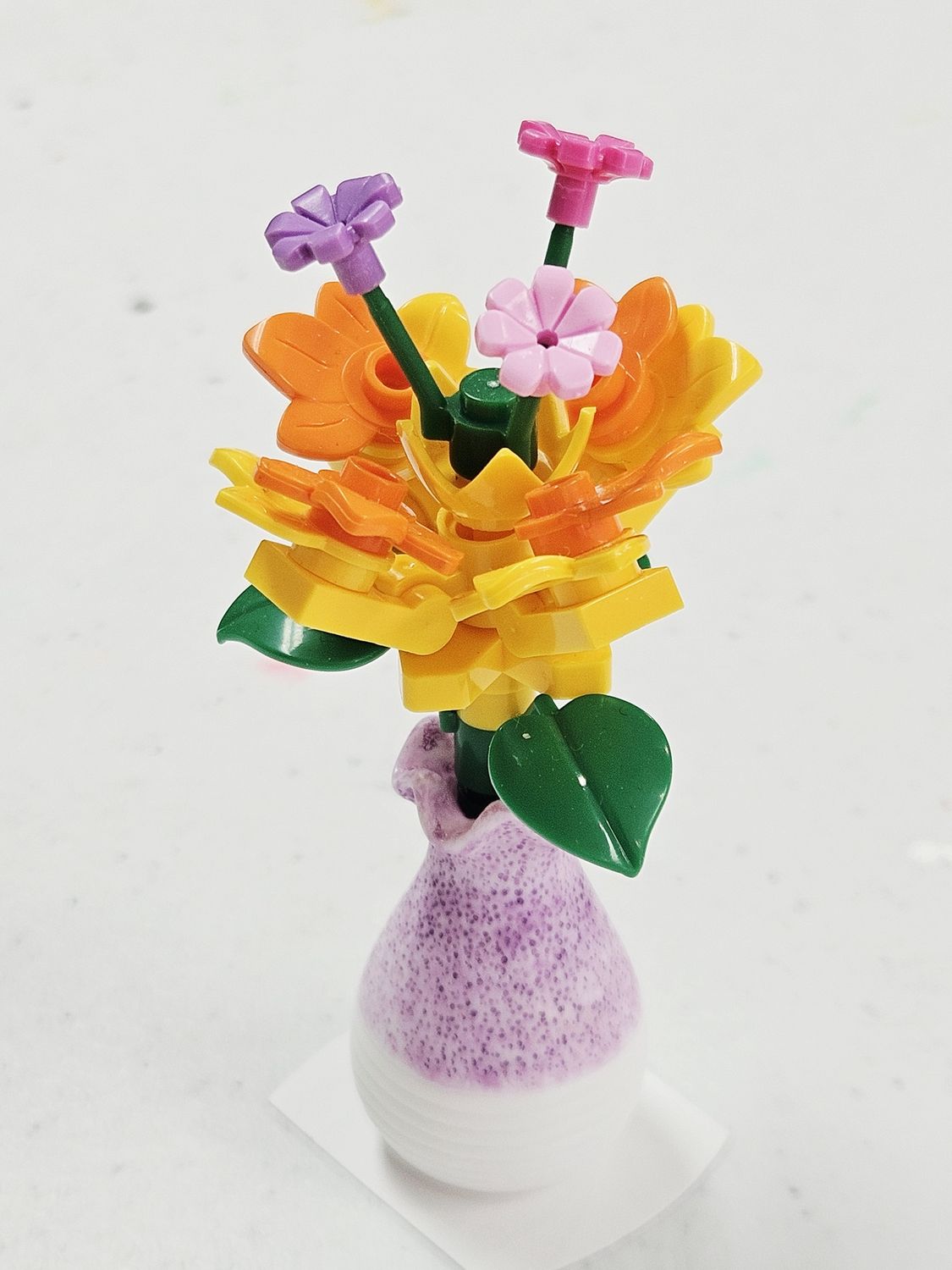 Yellow/orange flowers in purple vase
