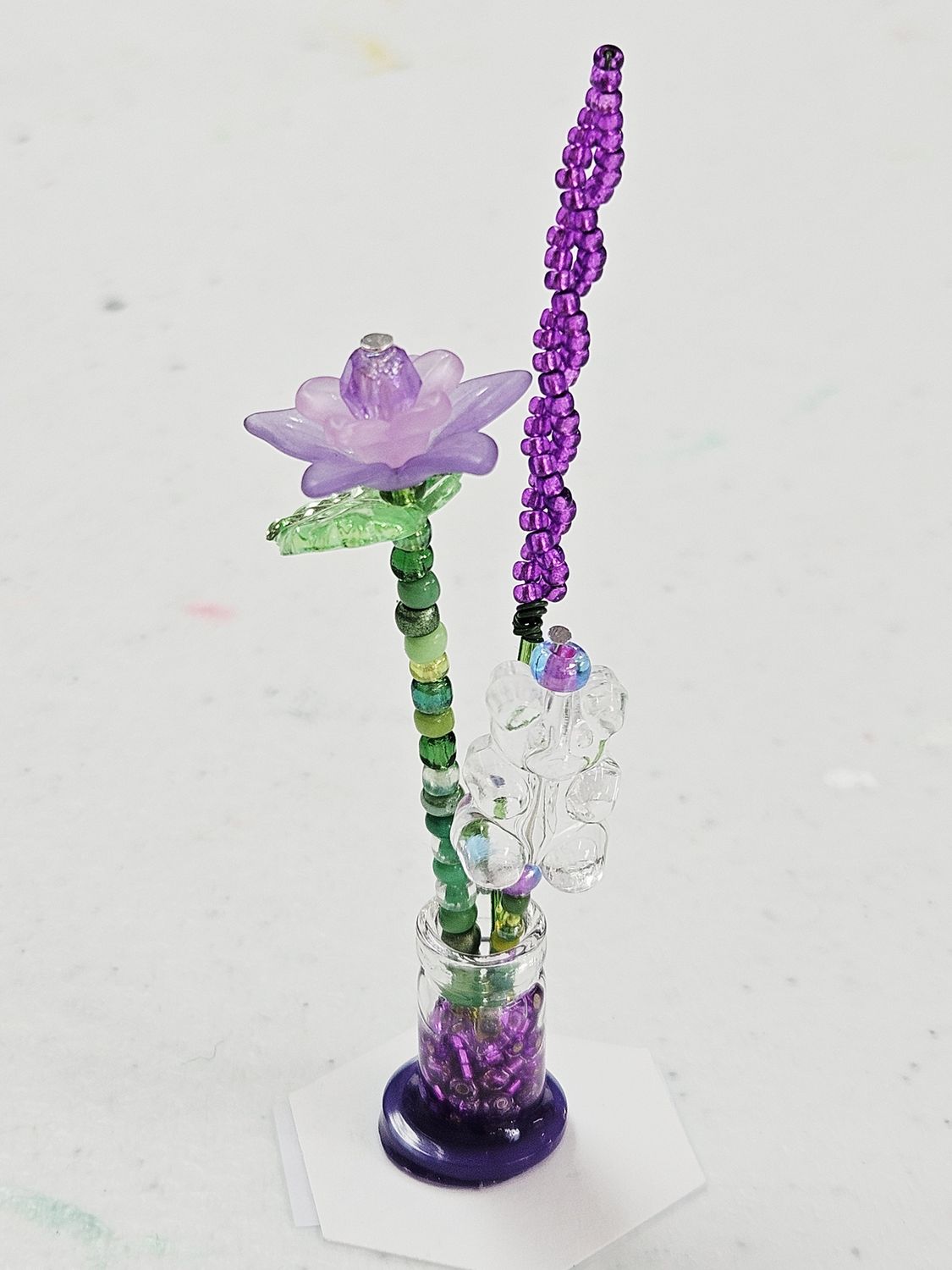 Purple beaded flowers with clear gummy bear in vase