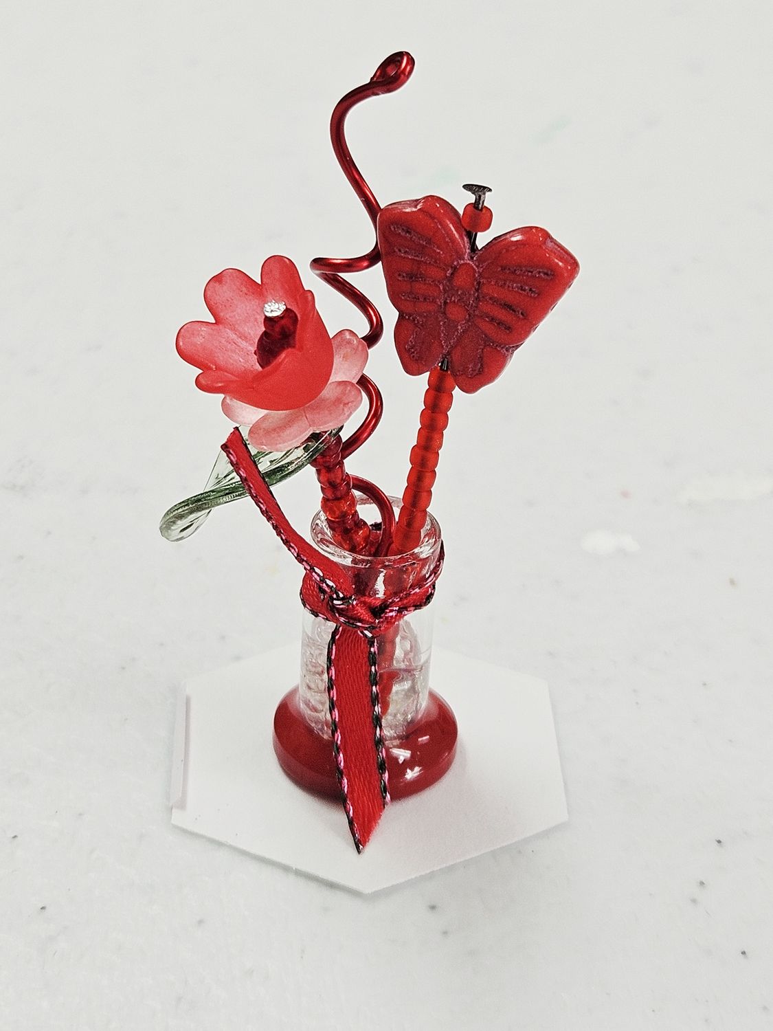 Red beaded flowers in mini glass vase