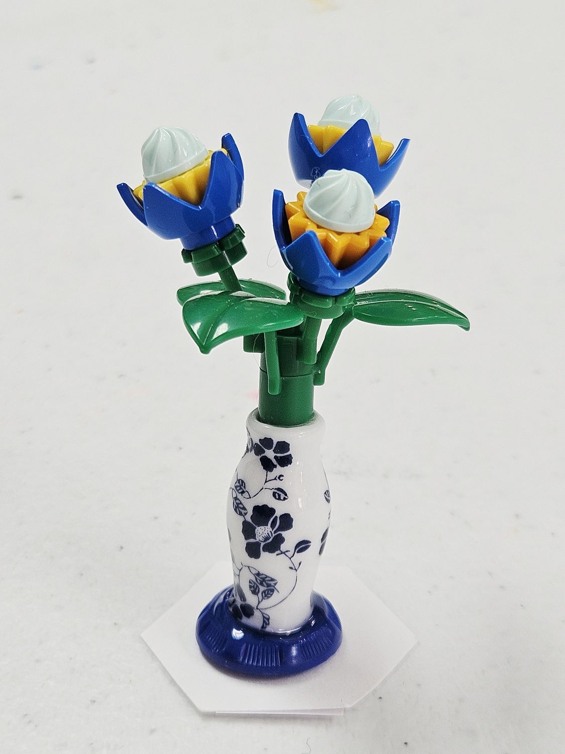 3 blue flowers in blue ceramic vase