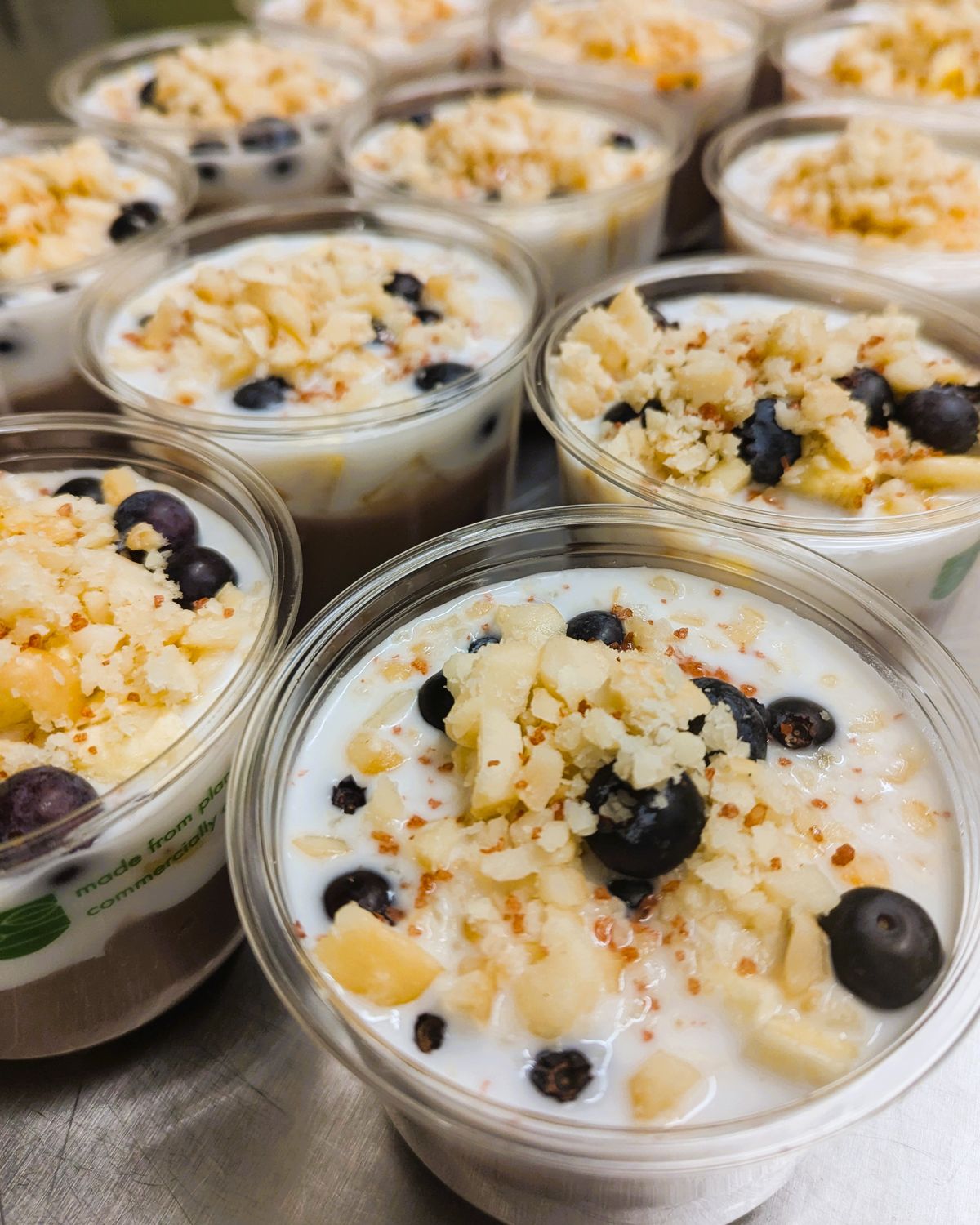 Multiple open cups of the Locavore Store's poi-faits. A base of fresh poi, coconut cream and topped with bananas, blueberries and macadamia nuts.