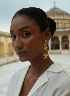 model with Christine Bekaert handcrafted gold-plated jewelry zappu fall earrings with star design