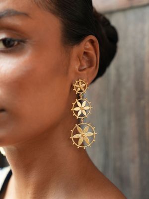 model wearing christine bekaert jewelry handcrafted gold-plated mulmul fall earrings with star design 
