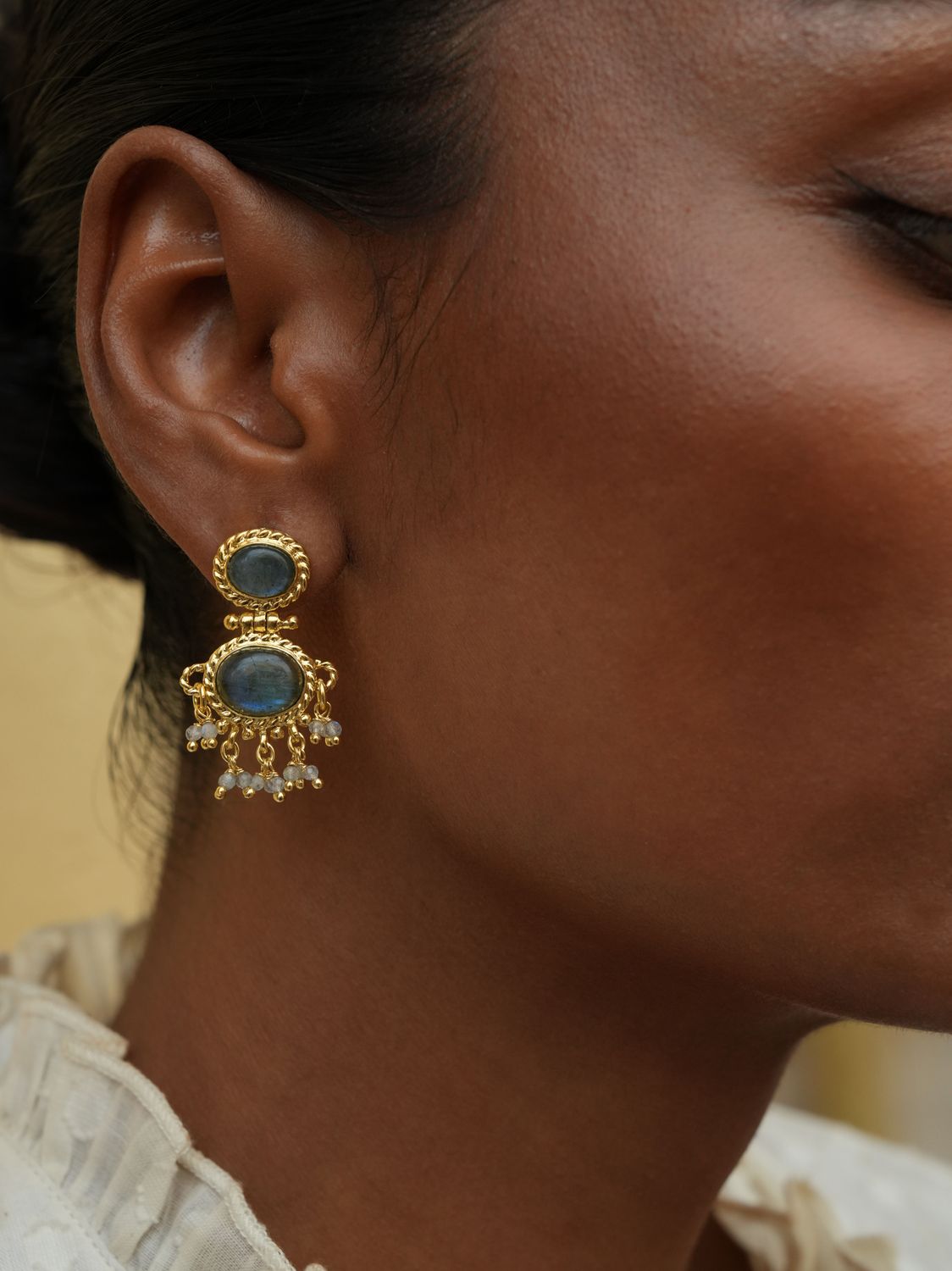 model wearing christine bekaert jewelry handcrafted gold-plated neberu earrings with natural gemstones labradorite
