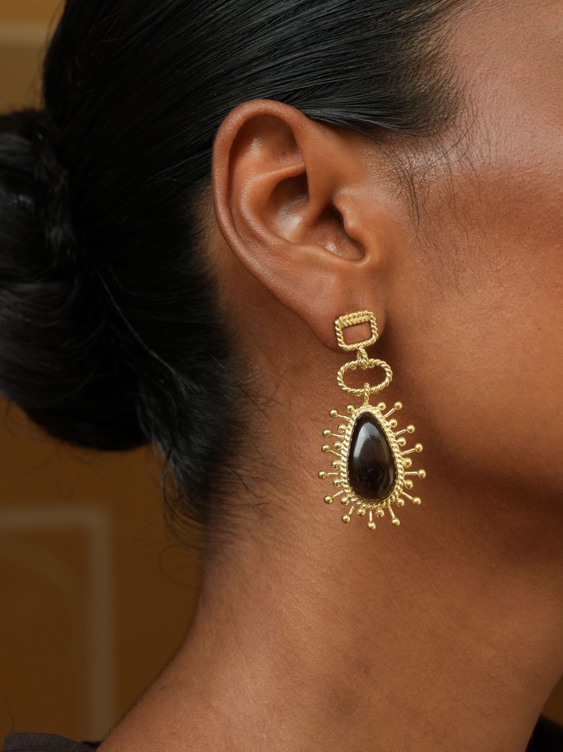 model wearing christine bekaert jewelry handcrafted gold-plated utu earrings with natural gemstones smokey quartz

