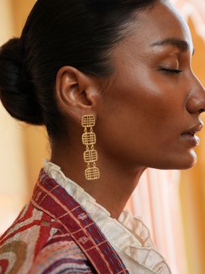 model wearing christine bekaert jewelry handcrafted gold-plated zenitha large earrings 