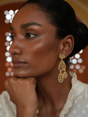 model wearing christine bekaert jewelry handcrafted gold-plated velari statement dangle earrings