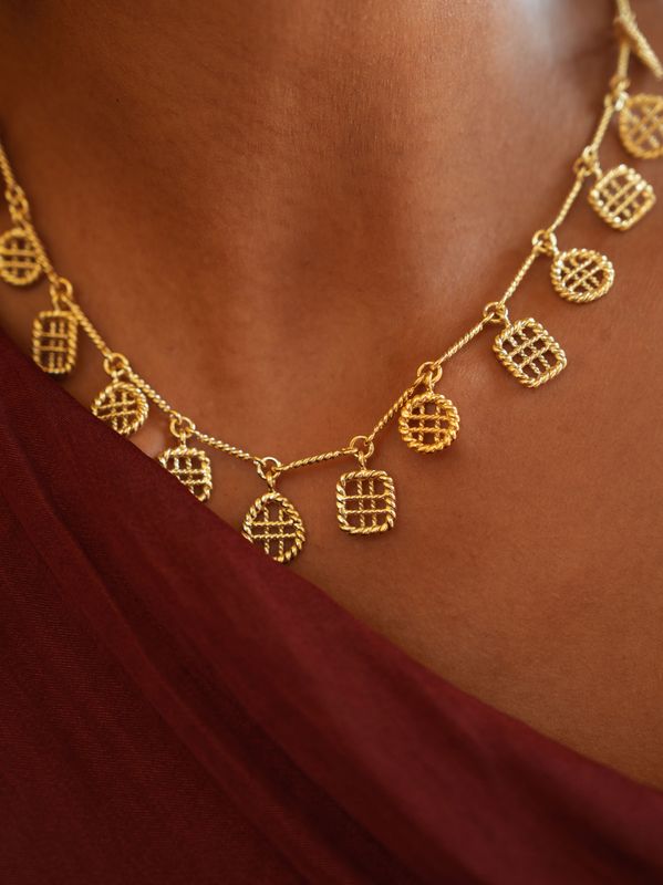 close up of model wearing christine bekaert jewelry handcrafted gold-plated statement noori beads necklace 