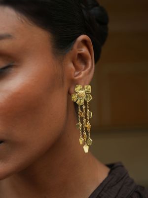 model wearing christine bekaert jewelry handcrafted gold-plated eternelle dangle small earrings also detachable studs 