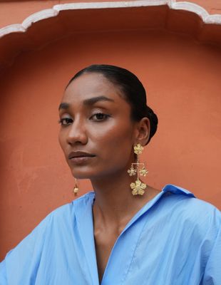 model wearing Christine Bekaert statement jewelry handcrafted gold-plated paper sonnets earrings 