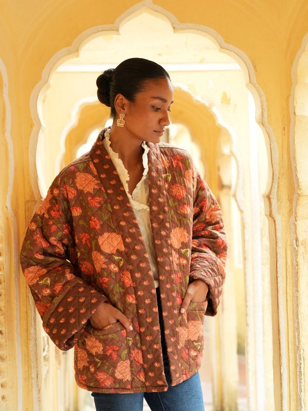 Model wearing short, quilted, fully reversible and handblock printed jacket designed by Christine Bekaert, brown base