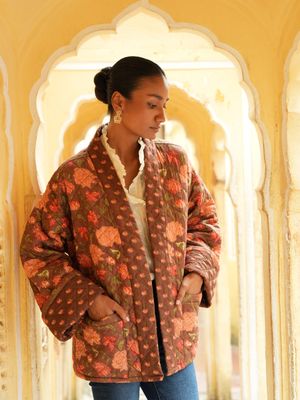 Model wearing short, quilted, fully reversible and handblock printed jacket designed by Christine Bekaert, brown base