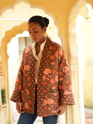 Model wearing short, quilted, fully reversible and handblock printed jacket designed by Christine Bekaert, brown base