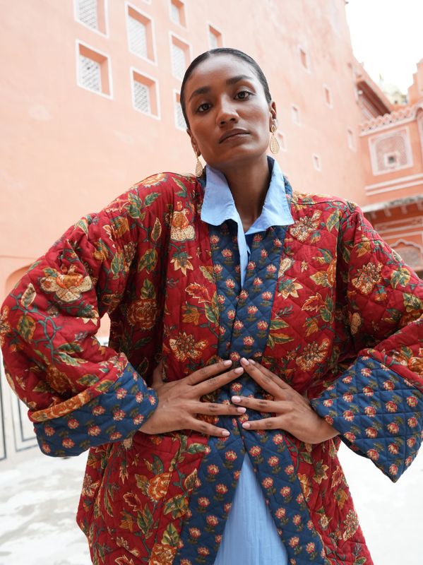Model wearing short, quilted, fully reversible and handblock printed jacket designed by Christine Bekaert, red and blue 