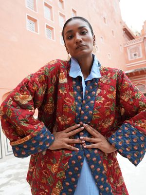 Model wearing short, quilted, fully reversible and handblock printed jacket designed by Christine Bekaert, red and blue 