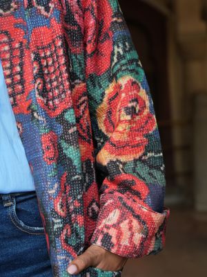 Model wearing long, jeans blue with red flowers jacket designed by Christine Bekaert, a statement piece made from old sarees