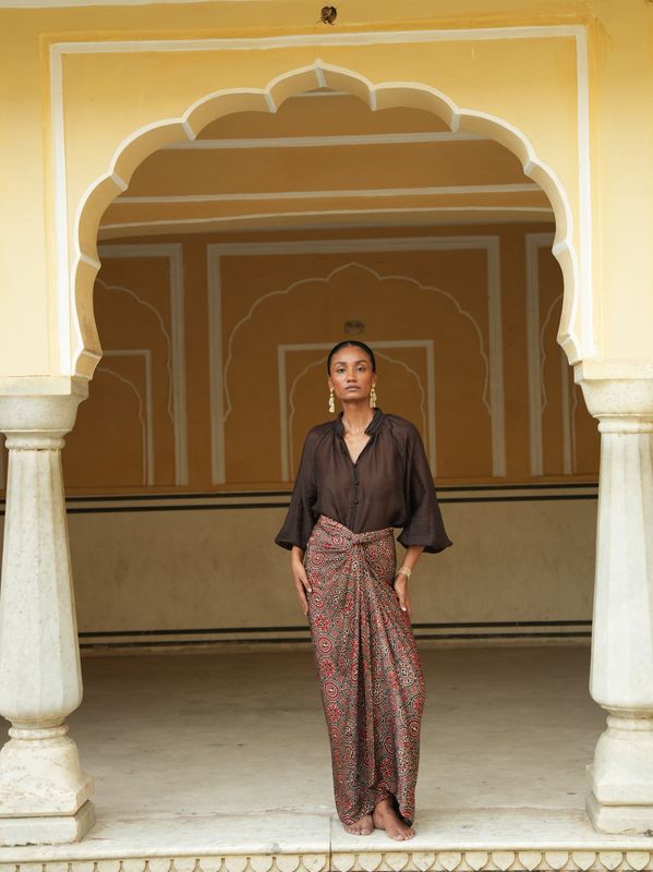 Model wearing statement wrap around skirt with brown red bagrou print designed by Christine Bekaert, unique piece in silk