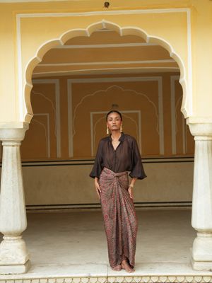 Model wearing statement wrap around skirt with brown red bagrou print designed by Christine Bekaert, unique piece in silk