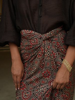 Model wearing statement wrap around skirt with brown red bagrou print designed by Christine Bekaert, unique piece in silk