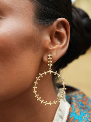 model wearing christine bekaert jewelry handcrafted gold-plated akkad medium hoops earrings