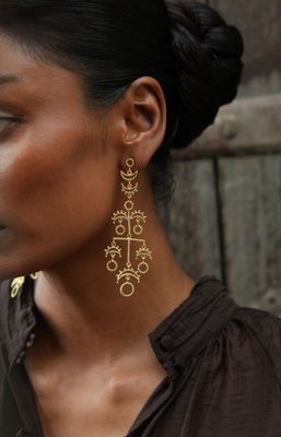 model wearing christine bekaert jewelry handcrafted gold-plated long nerigal earrings with star design 
