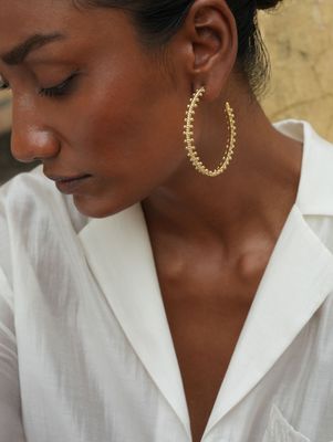 model wearing christine bekaert jewelry handcrafted gold-plated mitutu hoop earrings 