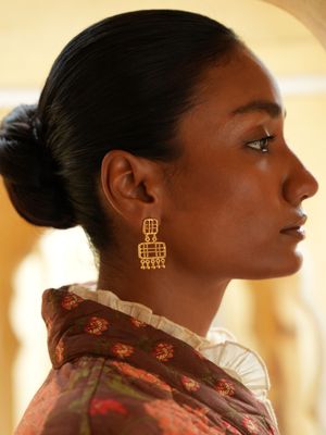 model wearing christine bekaert jewelry handcrafted gold-plated zenitha small earrings with gold beads
