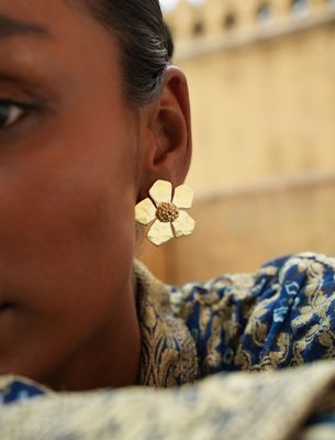 model wearing christine bekaert jewelry handcrafted gold-plated hammered everbloom large studs paper flowers 

