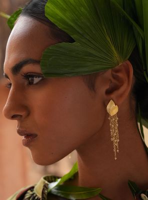 Product shot of medium flower earrings with gold beads by Belgian Christine Bekaert handcrafted statement jewelry on model