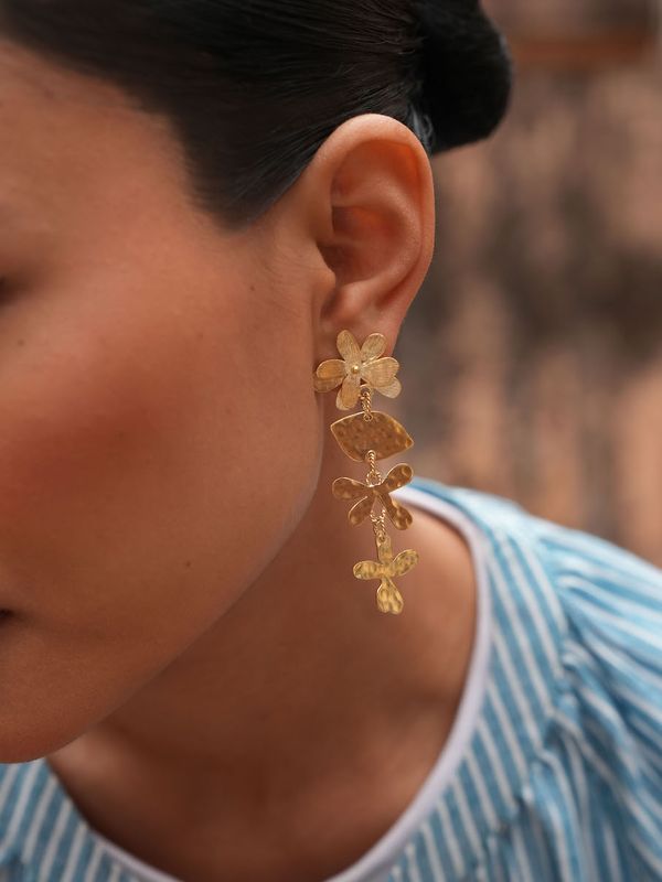 Product shot of medium flower earrings by Belgian Christine Bekaert handcrafted statement jewelry on model