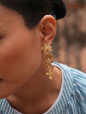 Product shot of medium flower earrings by Belgian Christine Bekaert handcrafted statement jewelry on model