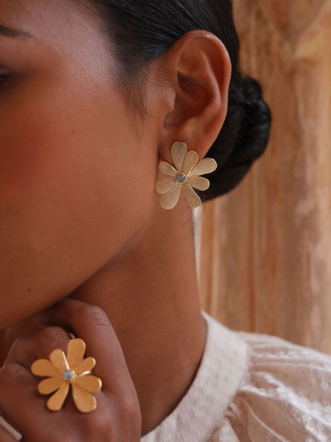 Product shot of medium flower earrings with white moonstone by Belgian Christine Bekaert handcrafted statement jewelry model