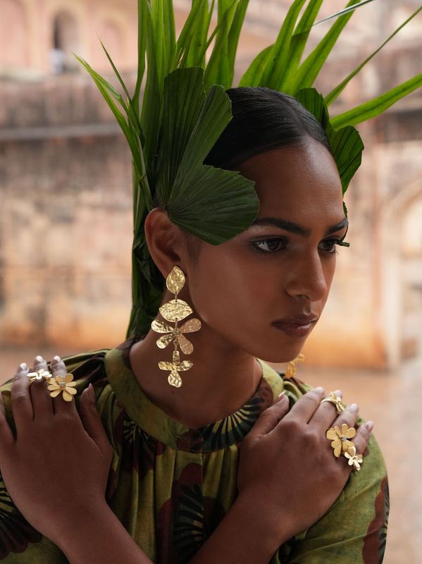 Product shot of large flower earrings by Belgian Christine Bekaert handcrafted statement jewelry on model