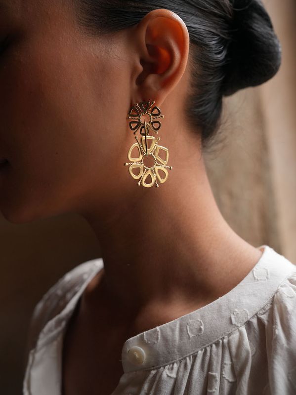 Product shot of small circular earrings by Belgian Christine Bekaert handcrafted statement jewelry on model