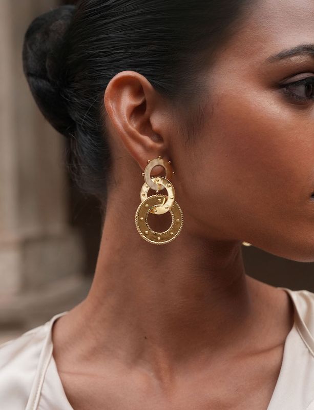 Product shot of large circular earrings by Belgian Christine Bekaert handcrafted statement jewelry on model