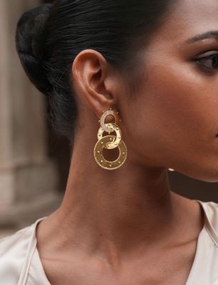 Product shot of large circular earrings by Belgian Christine Bekaert handcrafted statement jewelry on model