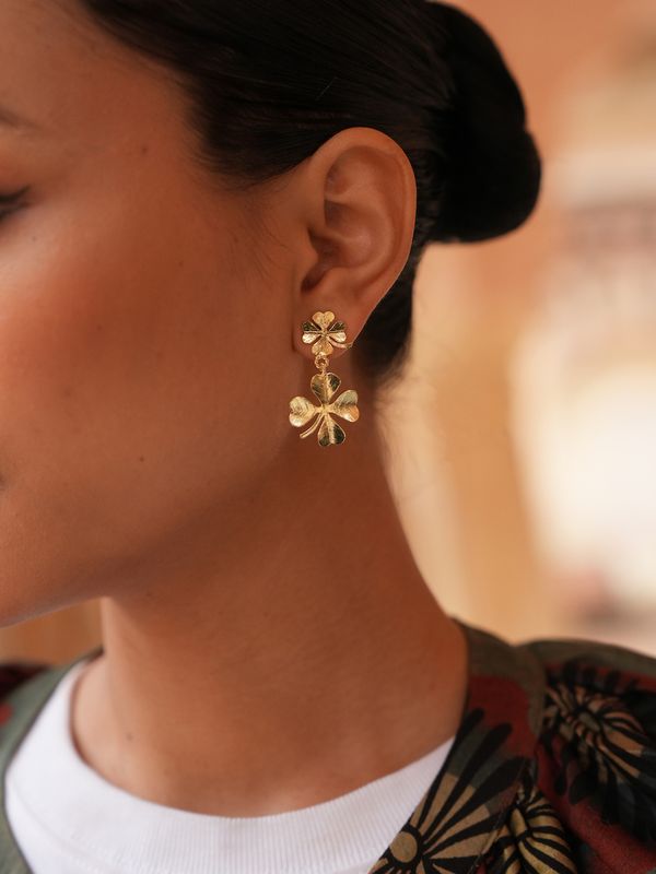 Product shot of small clover earrings by Belgian Christine Bekaert handcrafted statement jewelry on model