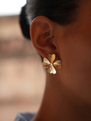 Product shot of medium clover earrings by Belgian Christine Bekaert handcrafted statement jewelry on model