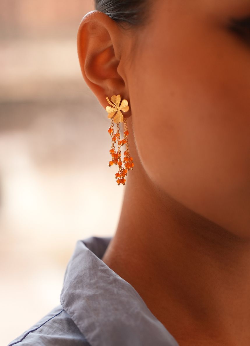 Product shot of small clover earrings with carnelian by Belgian Christine Bekaert handcrafted statement jewelry on model