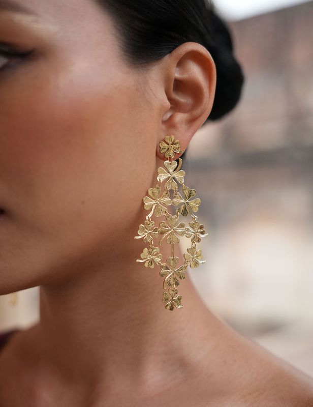 Product shot of large clover earrings by Belgian Christine Bekaert handcrafted statement jewelry on model