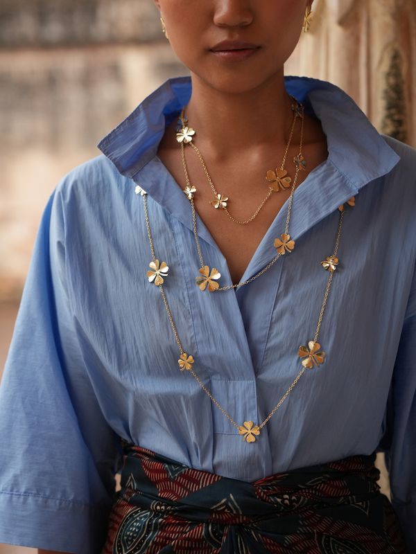 Product shot of long clover necklace by Belgian Christine Bekaert handcrafted statement jewelry on model