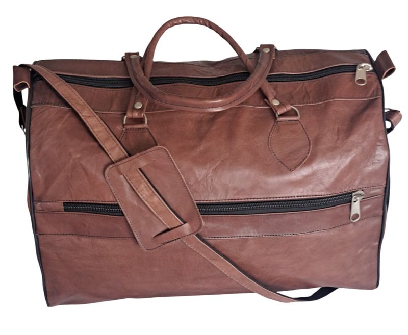 Detailansicht: Handgenähte Lederverbindungen und robuste, dunkle Metall-Reißverschlüsse der Reisetasche.
