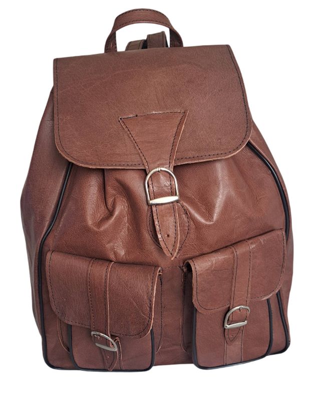 Vorderansicht des handgefertigten braunen Lederrucksacks mit zwei aufgesetzten Taschen und Schnallenverschluss.
