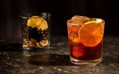 Refreshing amber mocktail with orange slices and ice, representing non-alcoholic drink mixes at Urban Market 1919.