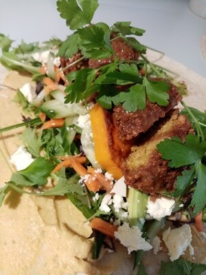 FALAFEL WRAP Wheat wrap filled with organic greens, hummus, pesto, chickpea and polenta falafel, feta, avocado, roasted pumpkin, cucumber and grated carrot.