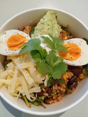 MEXI BOWL brown rice salad with corn, kidney beans, red onion, capsicum, baby spinach, coriander, mexican spices topped with guacamole, boiled egg, sour cream and edam.